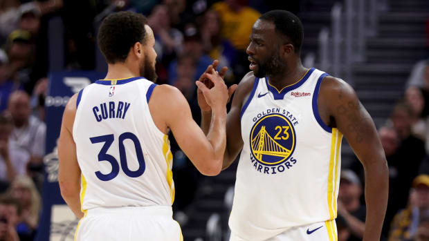 Warriors guard Stephen Curry congratulates forward Draymond Green during a game.
